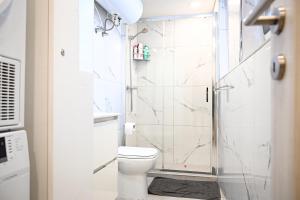 a white bathroom with a shower and a toilet at 10 Msida Park Residence in Msida +8 photos