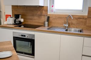 a kitchen with white cabinets and a sink and a stove at 10 Msida Park Residence in Msida