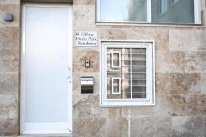 a white door on a building with a window at 10 Msida Park Residence in Msida