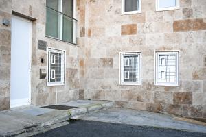 a brick building with a door and three windows at 10 Msida Park Residence in Msida
