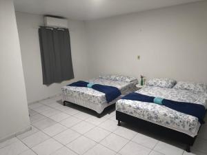 a room with two beds in a room with at Pousada Ouro branco Mossoró RN in Mossoró