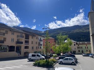 a city street with cars parked in a parking lot at Charmant duplex Proche station in Aime-La Plagne