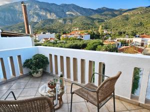 un balcone con sedie e un tavolo e montagne di Captain's Loft Villa a Marathokampos