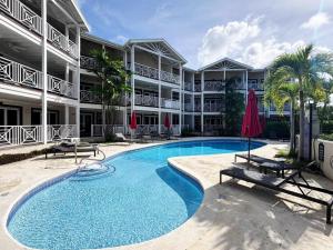a swimming pool in front of a building at Lantana 8 in Saint James