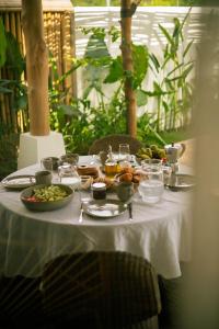 a table with a white table cloth with food on it at Irama Surf Villas - Private Pool Villas at Yoyos in Sekongkang +179 photos