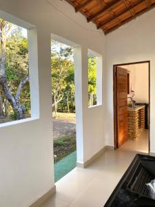 an empty room with two windows and a door at Casa Lilás no Vale do Capão in Vale do Capao