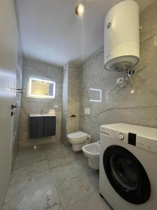 a bathroom with a toilet and a washing machine at Bega's BDuplex in Golem, Durrës in Golem +9 photos
