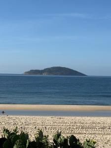 a beach with an island in the middle of the ocean at Incanto in Niterói +12 photos