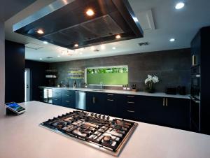 a kitchen with black cabinets and a stove top oven at Tropical Paradise in Leeward