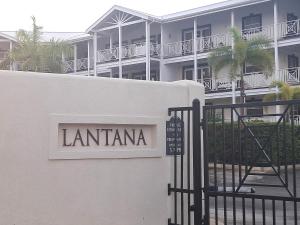 a sign for a hotel in front of a fence at Lantana 8 in Saint James