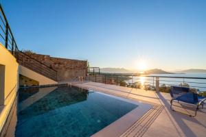 a swimming pool with a view of the ocean at The Captain's View in Aegina