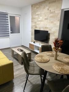 a living room with a table and chairs and a television at Vila Seawolf Apartments in Sutomore