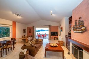 a living room with a couch and a fireplace at The Captain's View in Aegina