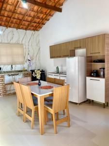 a kitchen with a table and chairs and a refrigerator at Casa Lilás no Vale do Capão in Vale do Capao