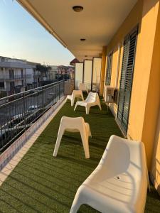 ein Balkon mit weißen Bänken an einem Gebäude in der Unterkunft IM 10 affittacamere in Cimitile