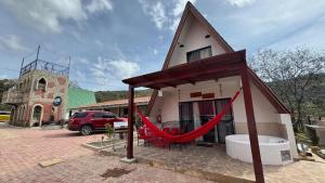 a small house with a red hammock outside of it at VERONA Cabañas in Samaipata +70 photos