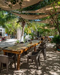 a wooden table and chairs under an umbrella at Camping, Glamping y Caravanas Dos Lunas in Celestún