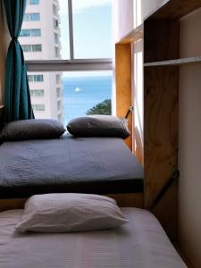 a bedroom with two beds and a window with the ocean at Aparta Suite Vista al Mar Rodadero in Gaira