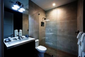 a bathroom with a sink and a toilet and a shower at Tropical Paradise in Leeward +3 photos