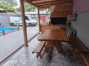 a wooden table and bench on a patio at jazmin apart iguazu in Puerto Iguazú