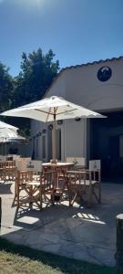 a picnic table with an umbrella in front of a building at Hosteria Alto Alegre in Coronel Moldes +9 photos