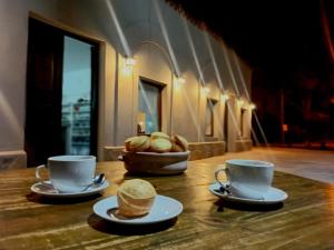 a table with two cups and a basket of bread at Hosteria Alto Alegre in Coronel Moldes