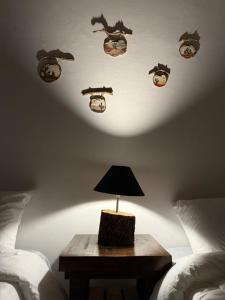 a lamp on a table in a bedroom with two beds at Hosteria Alto Alegre in Coronel Moldes