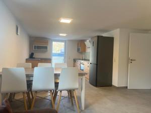 a kitchen with a table and chairs and a refrigerator at Gästehaus Wain I Monteur- & Ferienwohnung für 5 I 2 SZ I Terrasse I Parkplatz I WLAN in Wain