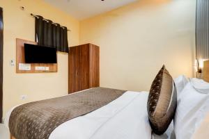 a bedroom with a bed with a television on the wall at Retrocka in Jāmb