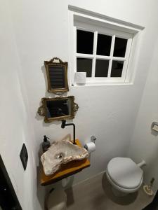 a bathroom with a toilet and a window at Gastehaus Watzko in Piçarras +17 photos