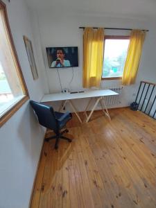 a desk in a room with a chair and a television at amailen ushuaia in Ushuaia
