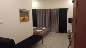 a hotel room with a couch and a window at Teaside Inns in Vythiri +27 photos