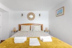 a bedroom with a bed with two white towels on it at Casita dos Avós in Alandroal