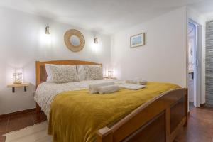 a bedroom with a bed with two towels on it at Casita dos Avós in Alandroal