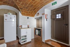 a kitchen with a fireplace and a door at Casita dos Avós in Alandroal