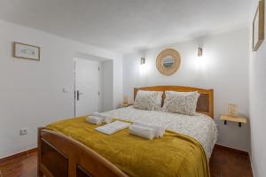a bedroom with a bed with two towels on it at Casita dos Avós in Alandroal