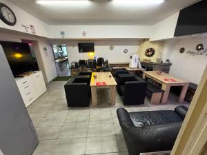 a living room with couches and tables and a kitchen at Pension Mediterrano - Monteurzimmer in Bedburg