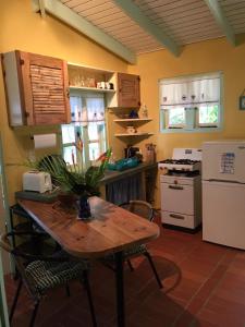 a kitchen with a table and a white refrigerator at Beautiful Cottage overlooking Sea in Goodwood