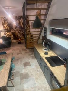 a kitchen with a sink and a table and a couch at L atelier du dormeur in Oberhoffen-sur-Moder