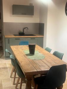 a wooden table with chairs and a cup on it at L atelier du dormeur in Oberhoffen-sur-Moder +1 photo