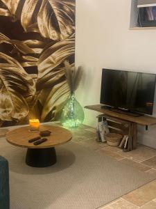 a living room with a table and a television at L atelier du dormeur in Oberhoffen-sur-Moder