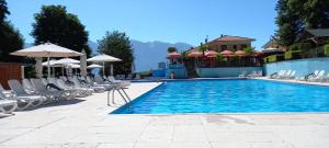 a swimming pool with chairs and umbrellas at Sunclass Tignale Bungalow Gardasee in Tignale
