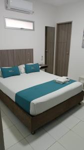 a bed with blue pillows in a room at House Concepcion in Estación El Salto