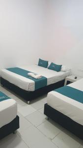 two beds with blue pillows in a room at House Concepcion in Estación El Salto