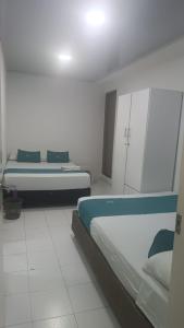 a white room with two beds and cabinets at House Concepcion in Estación El Salto