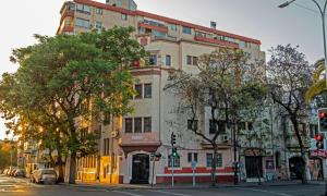 a large building on a city street with trees at Hotel La Castellana in Santiago