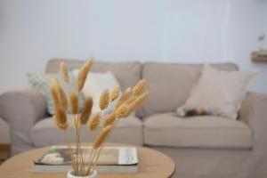 a living room with a table with a couch and a vase with wheat at Casa La Pedrera in Pedralba