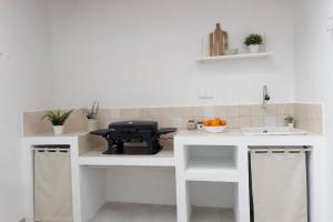 a kitchen with white counters and a black grill at Casa La Pedrera in Pedralba +32 photos