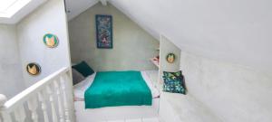 a small room with a green bed in a staircase at Studio en campagne in Retournac
