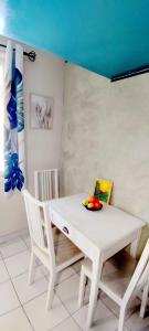 a white table and chairs with a bowl of fruit on it at Studio en campagne in Retournac
